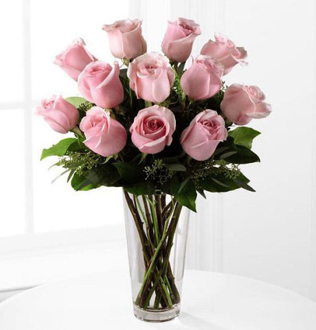 Dozen pink roses arranged in vase