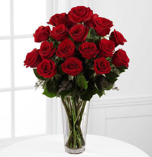 18 fancy red roses arranged in a glass vase