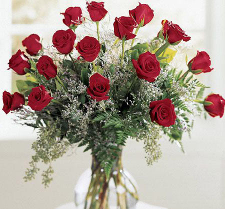 18 roses arranged in glass vase with filler and greens