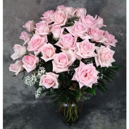 Dozen premium pink roses arranged in a  vase with filler and greens