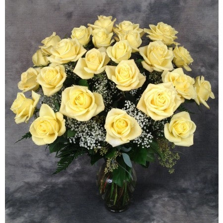 Dozen premium yellow roses arranged in a  vase with filler and greens