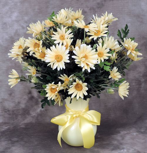 Artificial yellow daisies arranged in yellow vase