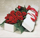 12 red roses in a box with greens