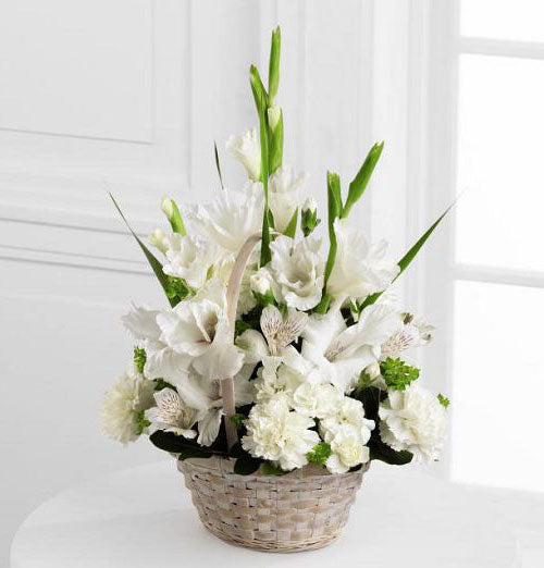 White handle basket filled with assorted white sympathy flowers Small