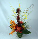 Island blooms tropical flower arrangement in vase with orchids and protea