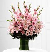 Gathering vase of blooming gladiolus for sympathy Medium