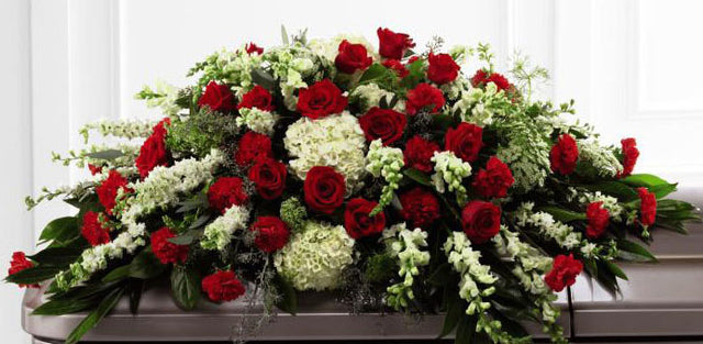 Funeral flower casket spray of red roses with assorted green flowers Large