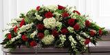 Funeral flower casket spray of red roses with assorted green flowers Medium