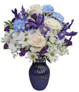 Blue and white fresh flowers in a blue glass vase Premium